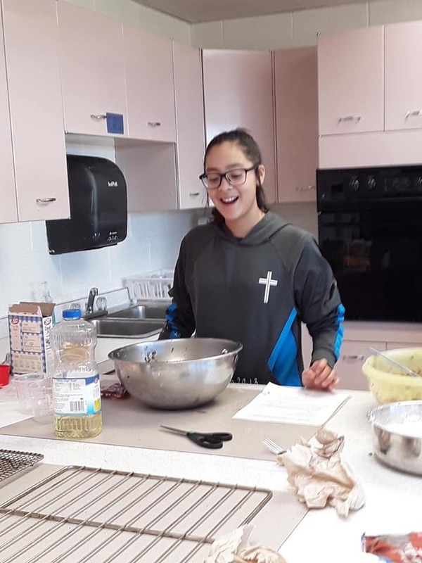 female student hard at work in a kitchen preparing a baked good